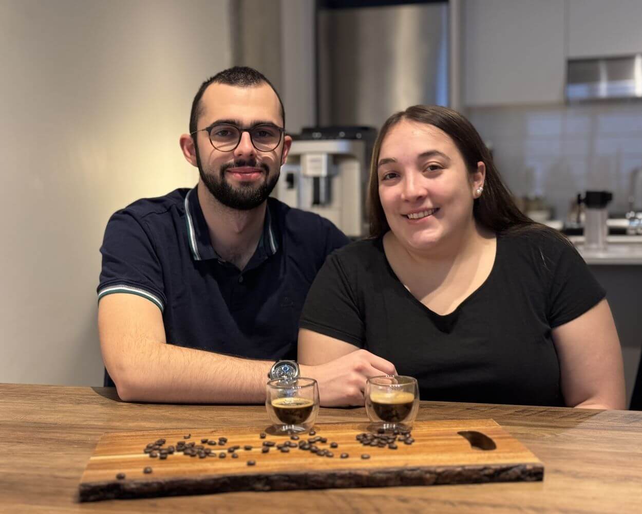 Antoine et Cloé qui présentent leur site internet Arômes Caféinés montrant deux expressos et des grains de café.