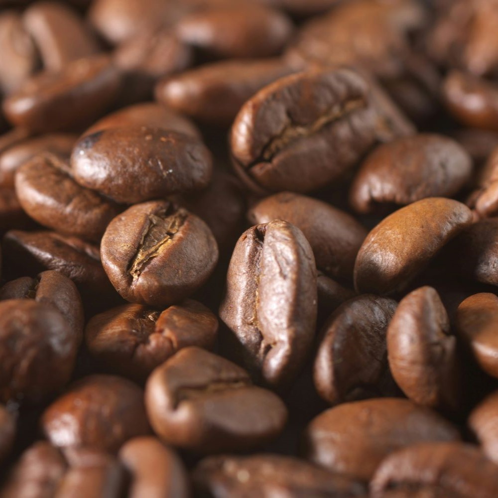 Très gros plan sur des grains de café torréfiés.