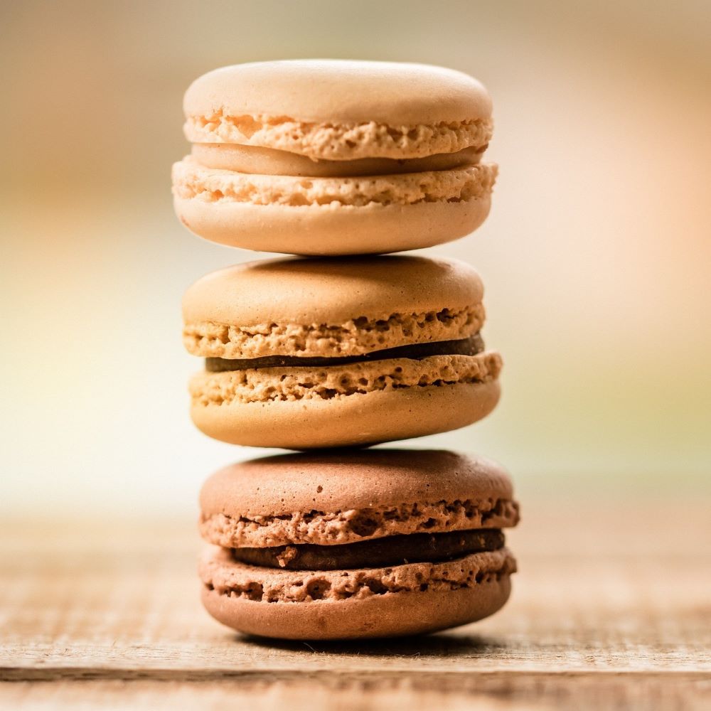 Trois cookies au café superposés sur une table en bois.