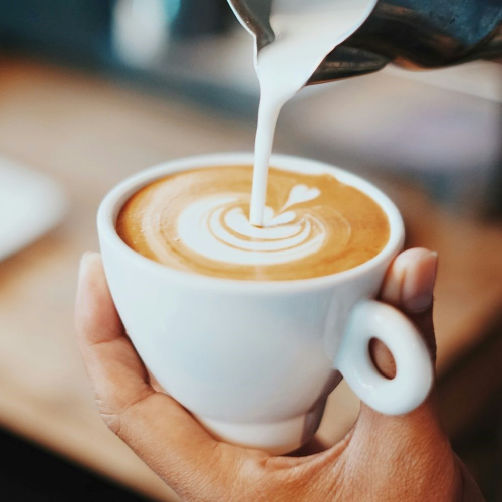 Gros plan sur la préparation d'un latte art en forme de Rosetta.