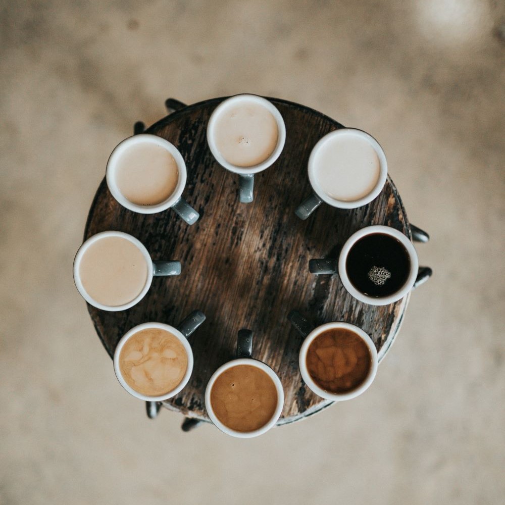 Plateau en bois avec différents types de café à partager.