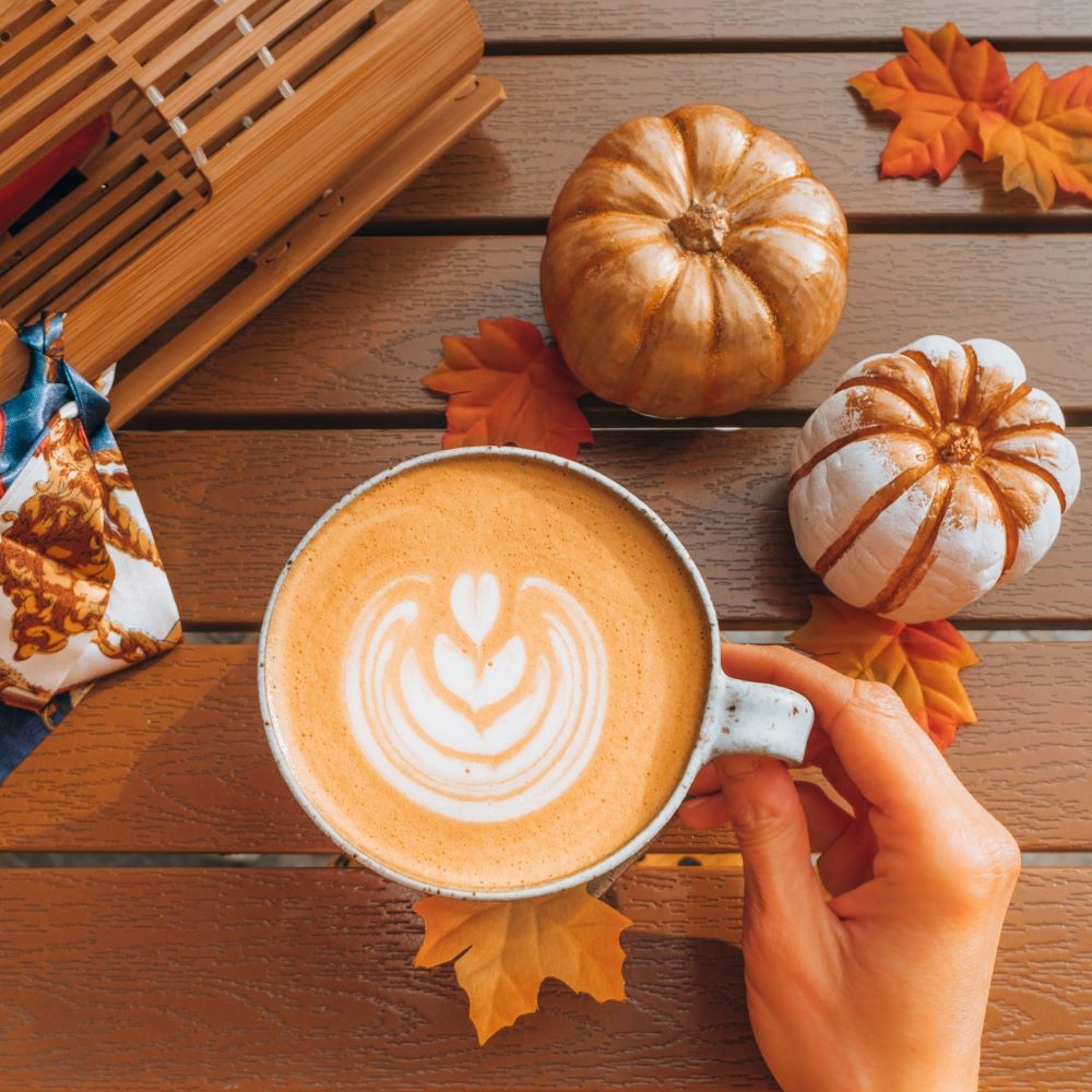 Latte à la citrouille épicée et café sur une table en bois avec des décoration d'Halloween.