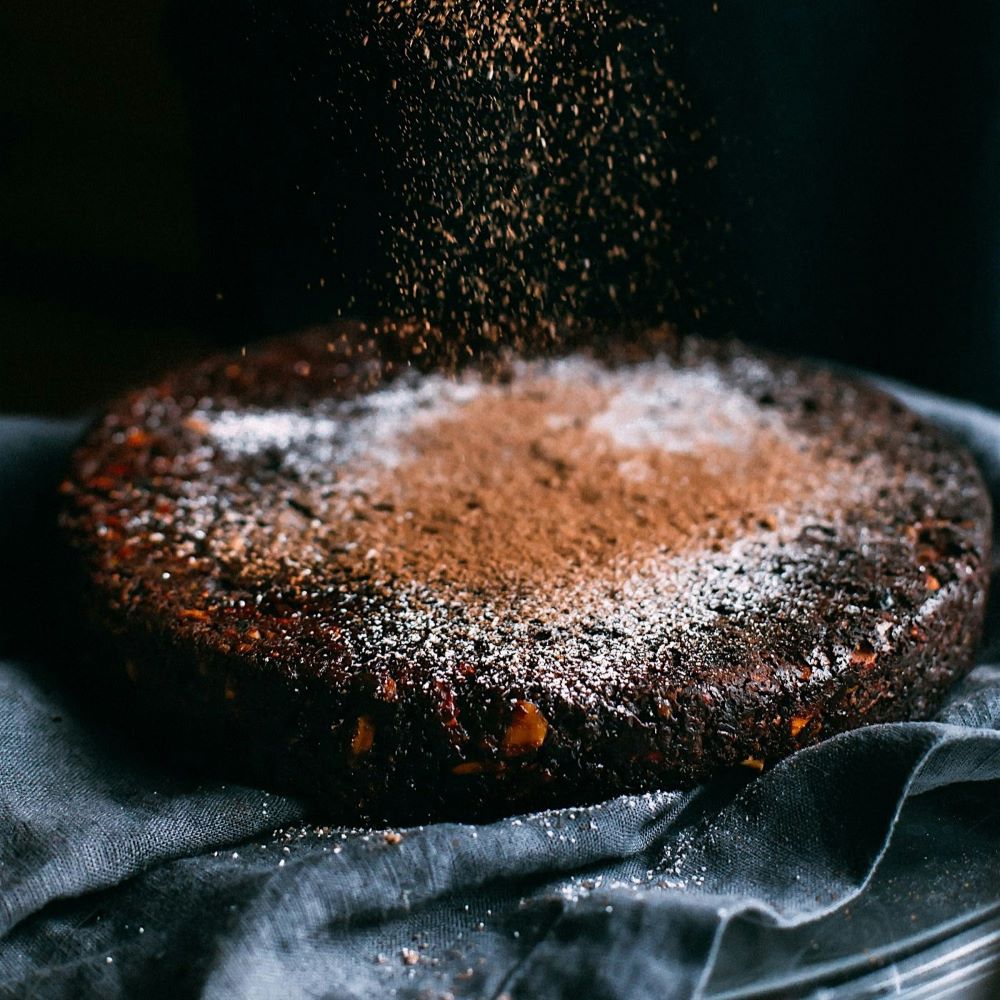 Saupoudrer du sucre roux sur un gâteau moelleux au café et noix de pécan.